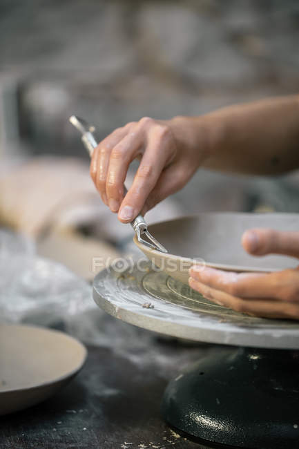 Imagen de la cosecha de manos artesanales tallando plato de arcilla - foto de stock