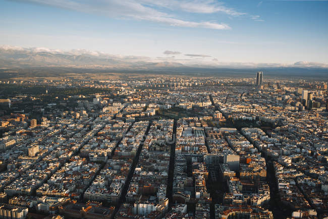 Повітряний знімок міста з щільною інфраструктурою та горами на фоні . — стокове фото