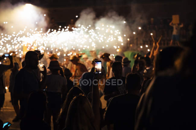 Silhouettes of people taking photo of fireworks festival — Stock Photo