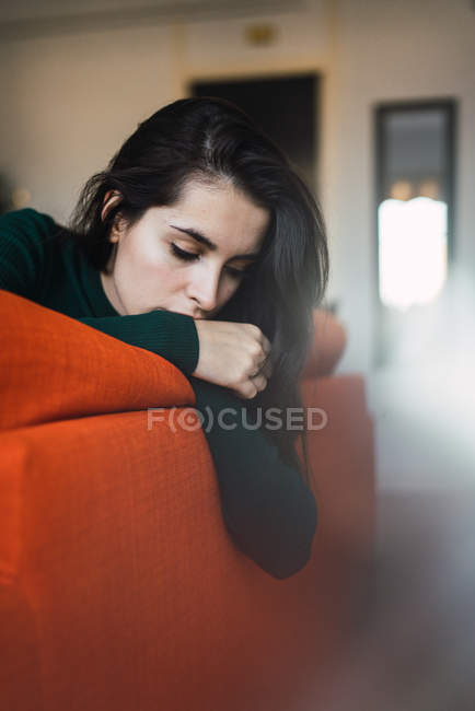 Ritratto di ragazza bruna sdraiata sul bordo del divano — Foto stock