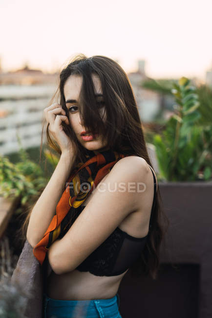 Porträt eines brünetten Mädchens, das auf dem Balkon posiert und in die Kamera blickt — Stockfoto