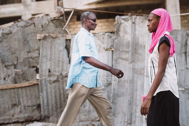 Багатий африканський чоловік і бідна жінка йдуть вулицею один до одного.. — стокове фото