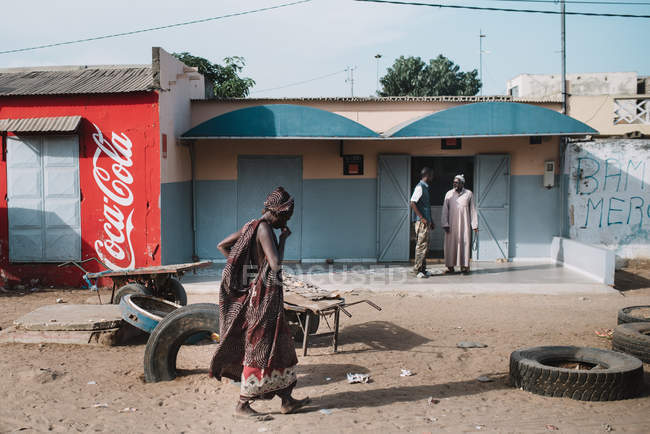 Goree, senegal- 6. Dezember 2017: Seitenansicht von Menschen auf der Straße der armen Stadt in hellem Licht. — Stockfoto