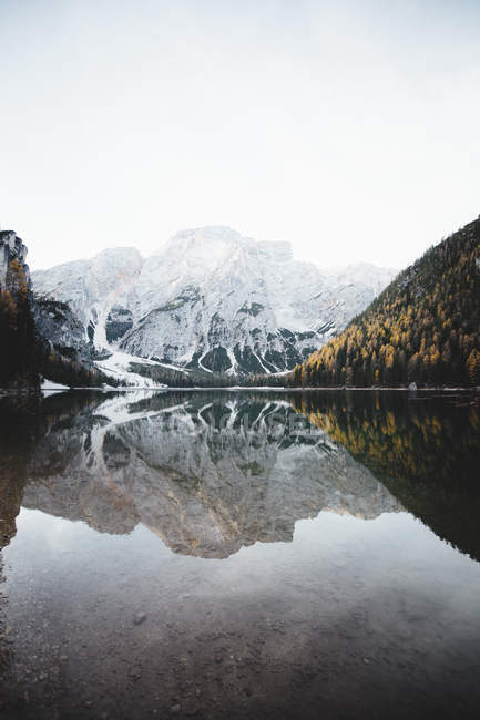Мальовниче спокійне гірське озеро та засніжена гора на фоні — стокове фото