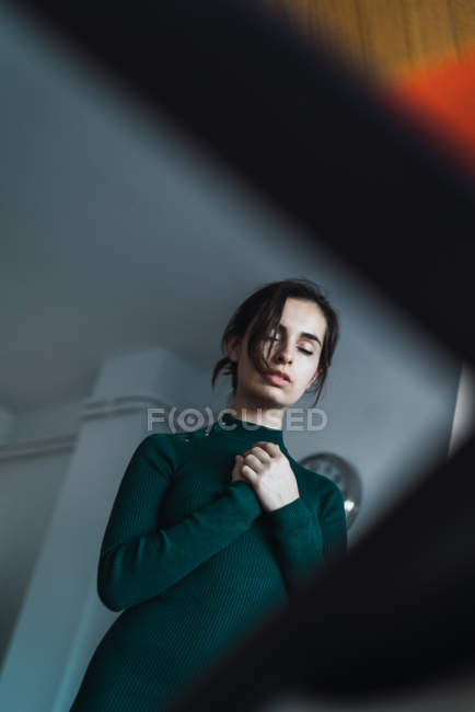 Hochwinkelblick auf brünettes Mädchen, das mit geschlossenen Augen und Armen auf der Brust posiert — Stockfoto
