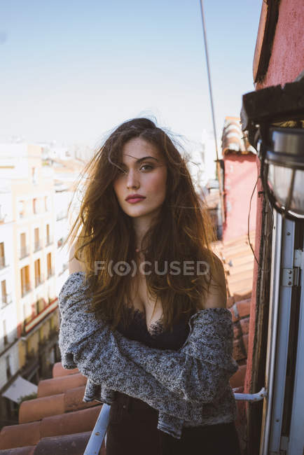 Seductive brunette girl posing at balcony and looking at camera — Stock Photo