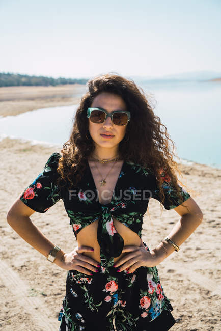 Donna in occhiali da sole posa vicino lago deserto — Foto stock