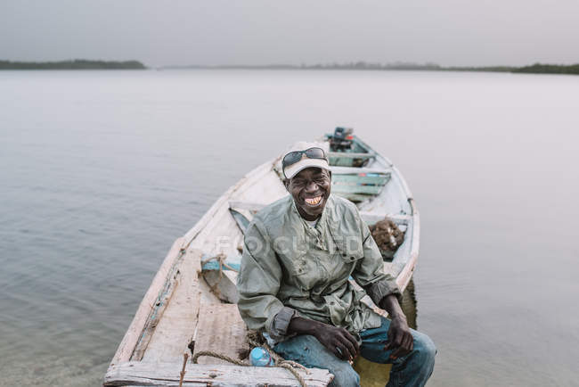 Goree, Senegal- diciembre 6, 2017: Hombre viejo sonriente en barco en el río - foto de stock