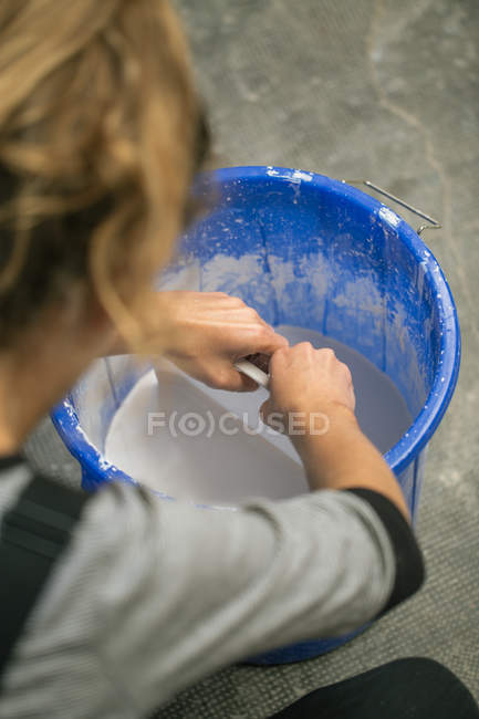 Over shoulder view of potter working with liquid clay in busket — Stock Photo
