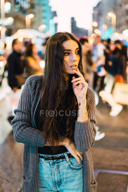 Portrait of delicate brunette girl posing among pedestrians at street — Stock Photo