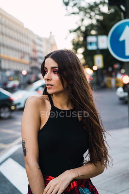 Morena elegante posando na estrada urbana e olhando para longe — Fotografia de Stock