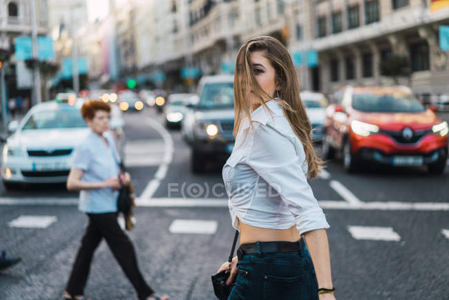 Side view of brunette girl walking on crosswalk — Stock Photo