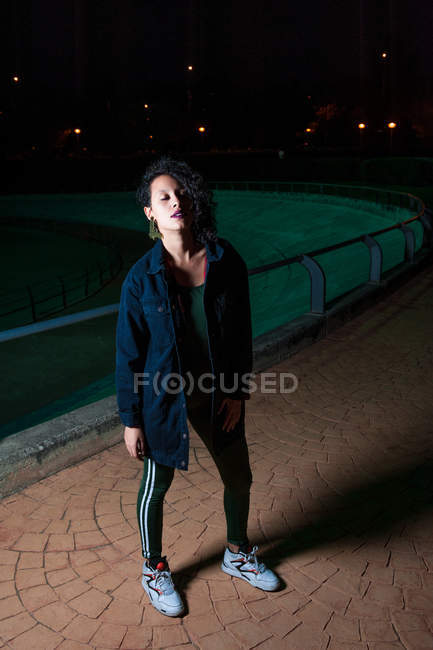 Portrait de fille en tenue urbaine posant la nuit scène de rue avec les yeux fermés — Photo de stock
