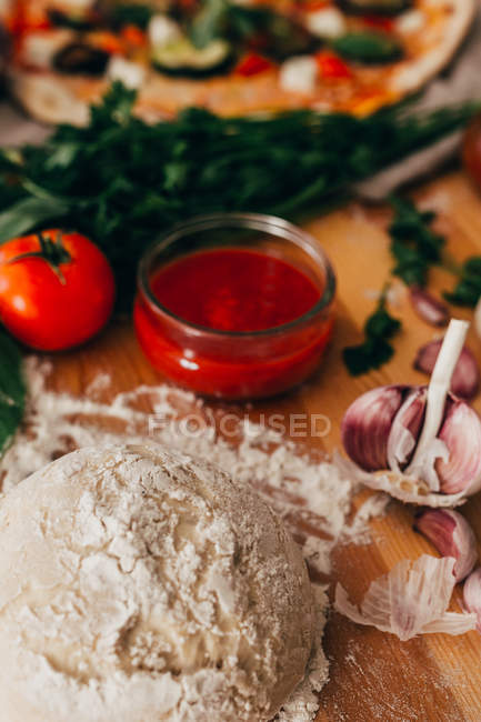 Kneaded dough on wood in arrangement of cooking ingredients. — Stock Photo