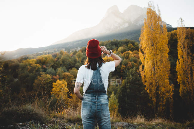 Rear view of woman in red hat posing at nature — Stock Photo