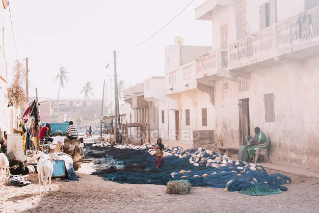 La gente en la calle de la pequeña ciudad africana en el día soleado. - foto de stock