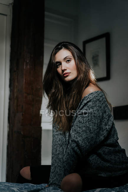 Дивовижна молода дівчина брюнетка в светрі накидається і дивиться на камеру . — стокове фото