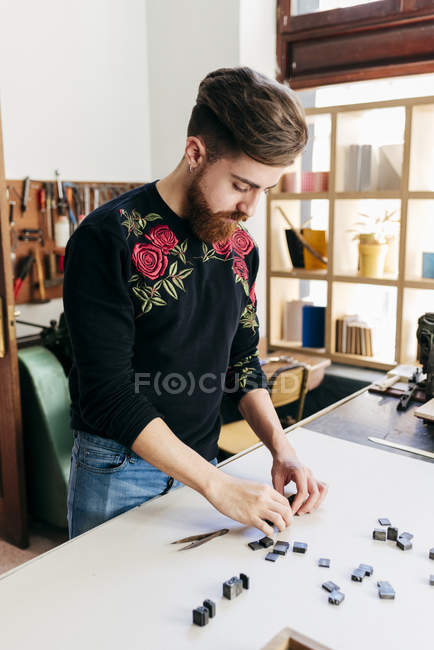 Arbeiter arrangiert Buchstabenmuster auf Tisch — Stockfoto