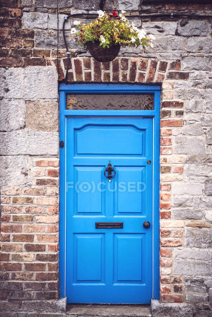 Ярко-голубая дверь в кирпичной стене сельского дома . — стоковое фото