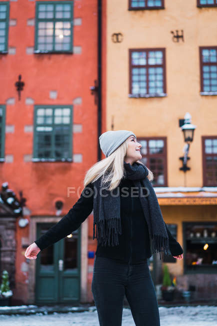 Vista frontale di donna allegra in posa sulla strada in inverno — Foto stock