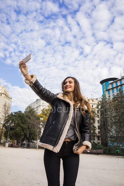 Vue grand angle de fille brune prenant selfie sur la scène urbaine — Photo de stock
