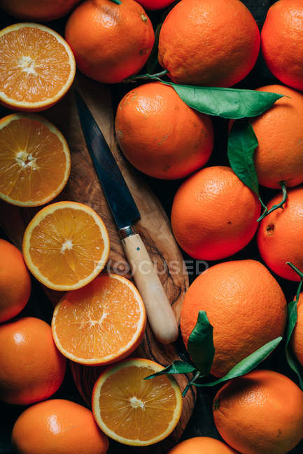 Натюрморт з сільським ножем та апельсинами на дошці — стокове фото