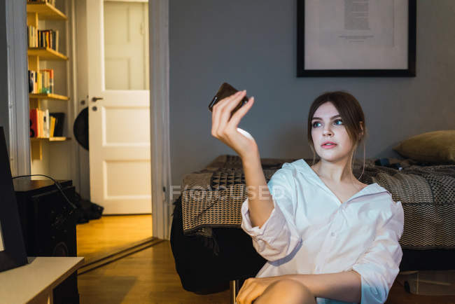 Портрет жінки в сорочці, що сидить на підлозі вдома і приймає селфі — стокове фото
