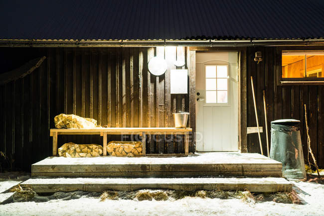 Facciata di piccolo edificio in legno nella notte d'inverno — Foto stock
