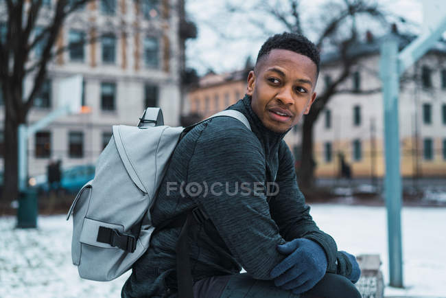 Side view of man with backpack posing on playground — Stock Photo