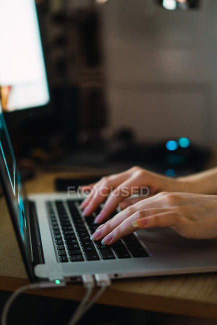 Crop female hands typing on laptop at table. — Stock Photo