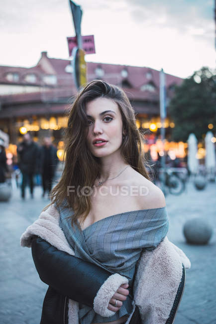 Portrait of sensual brunette woman taking of coat on street — Stock Photo