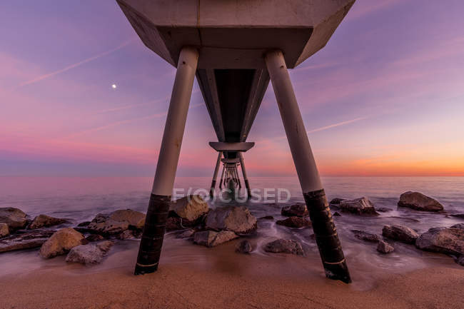 From below diminishing perspective shot of pier against sunset sky — Stock Photo