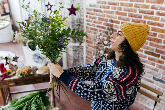 Vue à angle bas de la femme en tablier arrangeant des fleurs — Photo de stock
