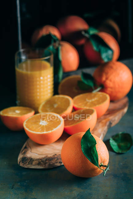 Close up view of fresh oranges and glass oforange juice — Stock Photo