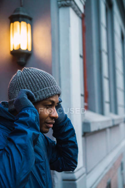 Side view of black man putting on hat before jogging — Stock Photo