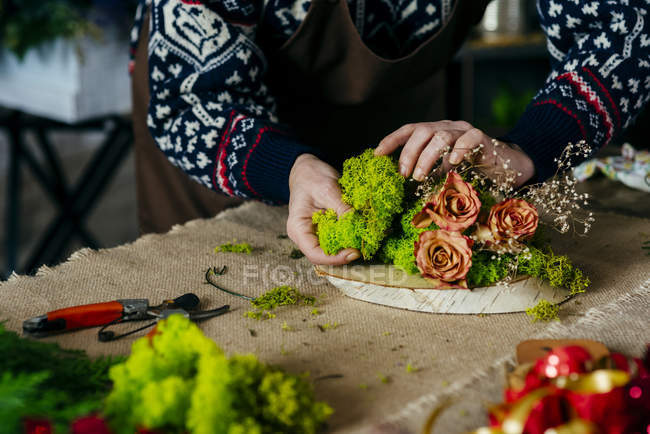 Cultiver les mains féminines faisant composition florale sur la table — Photo de stock