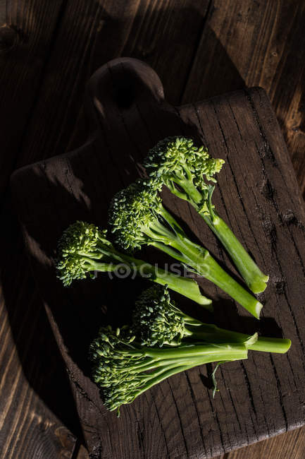 Directamente desde arriba vista de verduras frescas de brócoli bimi en tablero de madera . - foto de stock