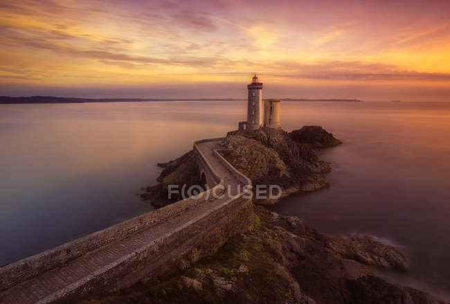 Aerial view to road to lighthouse built on hill at seaside in sunset lights. — Stock Photo