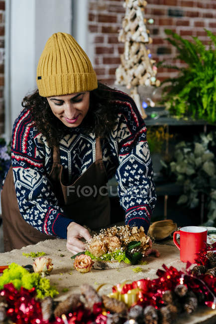 Portrait de femme faisant composition florale sur table avec tissu de sac — Photo de stock