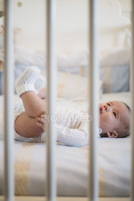 Vista lateral del niño pequeño en la cama - foto de stock