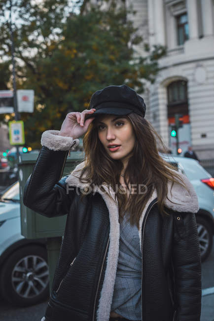 Portrait of woman in putting cap on at street scene — Stock Photo