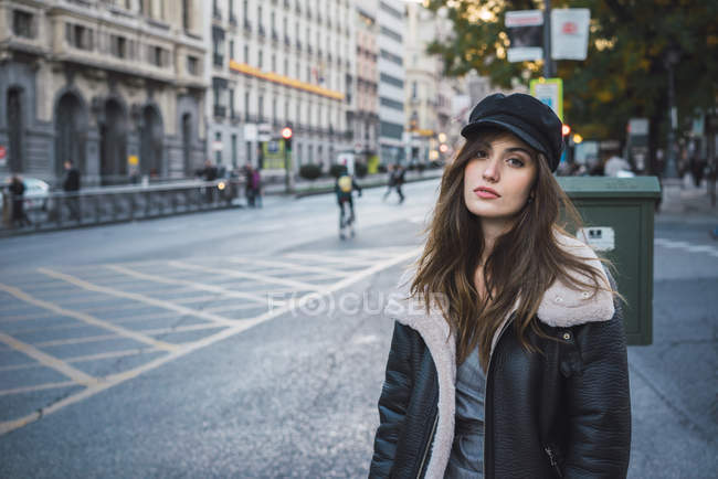 Donna in elegante cappello in posa sulla strada e guardando la fotocamera — Foto stock