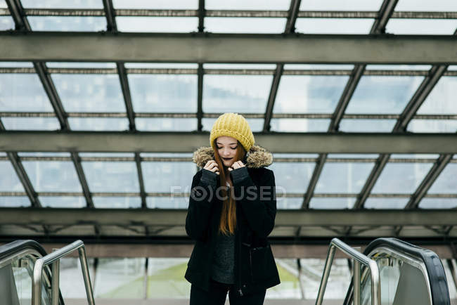 Porträt einer jungen Frau posiert im Mantel in Einkaufszentrum — Stockfoto