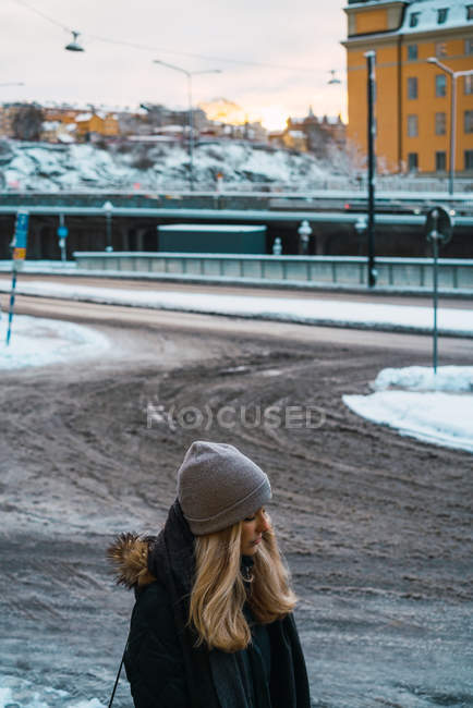 Crop woman walking on city street and looking down — Stock Photo