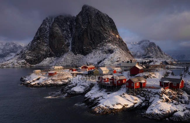 Luftaufnahme zu kleinen roten Häusern in einem Dorf am Seeufer in den Bergen — Stockfoto