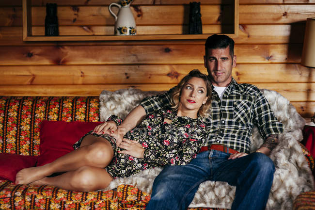 Vorderseite des umarmenden Paares entspannt auf der Couch — Stockfoto