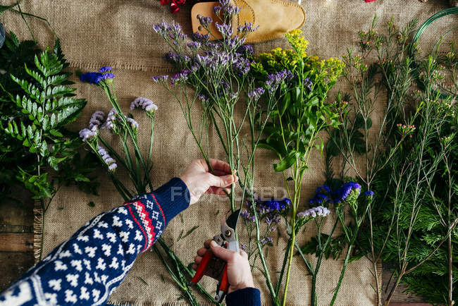Manos de las cosechas cortar flores sobre tela de lino . - foto de stock