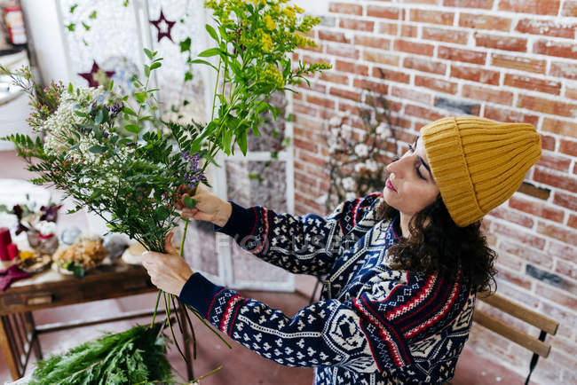 Vue à angle bas de la femme arrangeant des fleurs à l'atelier floral — Photo de stock