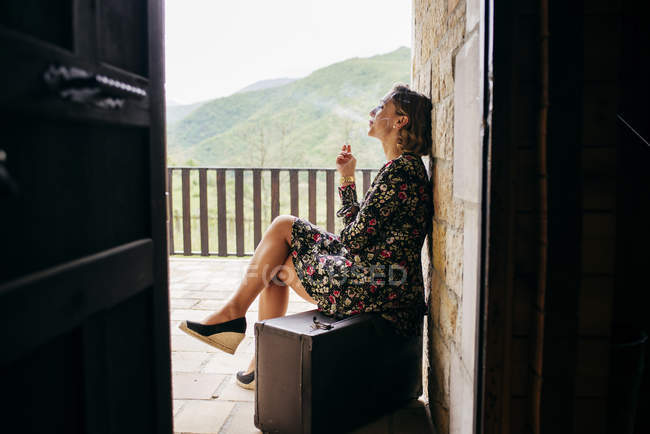 Seitenansicht einer rauchenden Frau auf der Veranda — Stockfoto