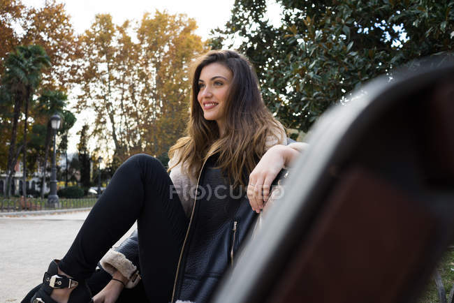 Side view of brunette woman sitting on bench — Stock Photo